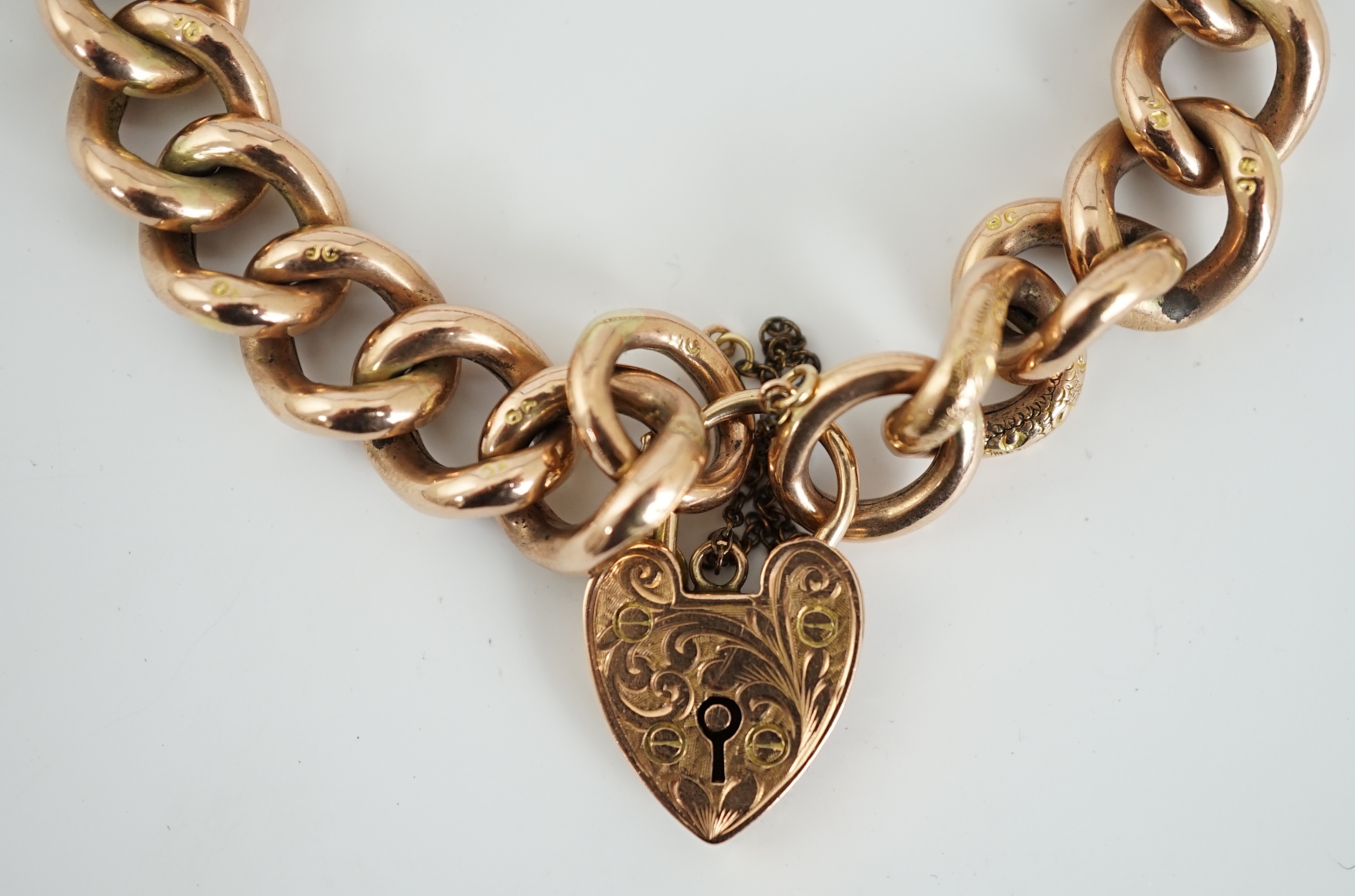 An Edwardian 9ct engraved curb link bracelet, with heart shape padlock clasp